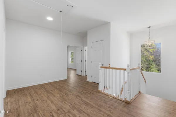 a view of a hallway with wooden floor and entryway