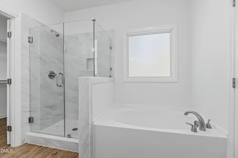 a white bath tub sitting next to a shower
