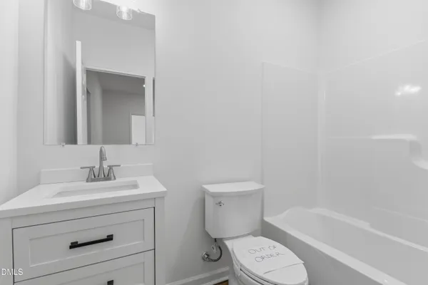 a bathroom with a toilet sink vanity tub and mirror