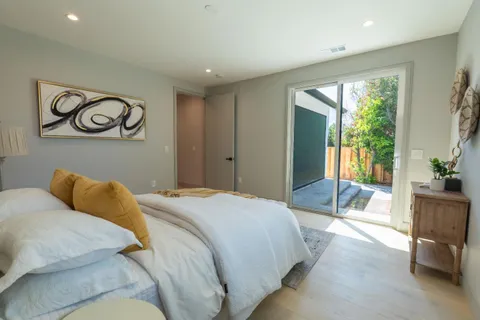 a bedroom with a bed and painting on the wall