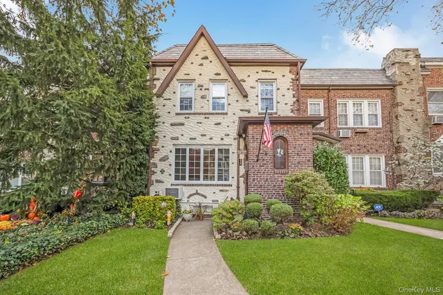 a front view of a house with a yard and potted plants