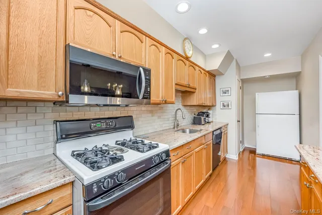 a kitchen with stainless steel appliances granite countertop a stove a sink and a microwave