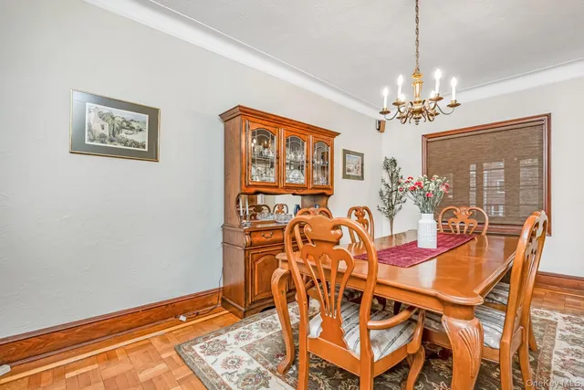 a view of a dining room with furniture a chandelier and window