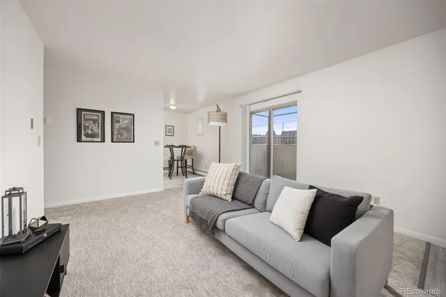 a living room with furniture and painting on the wall