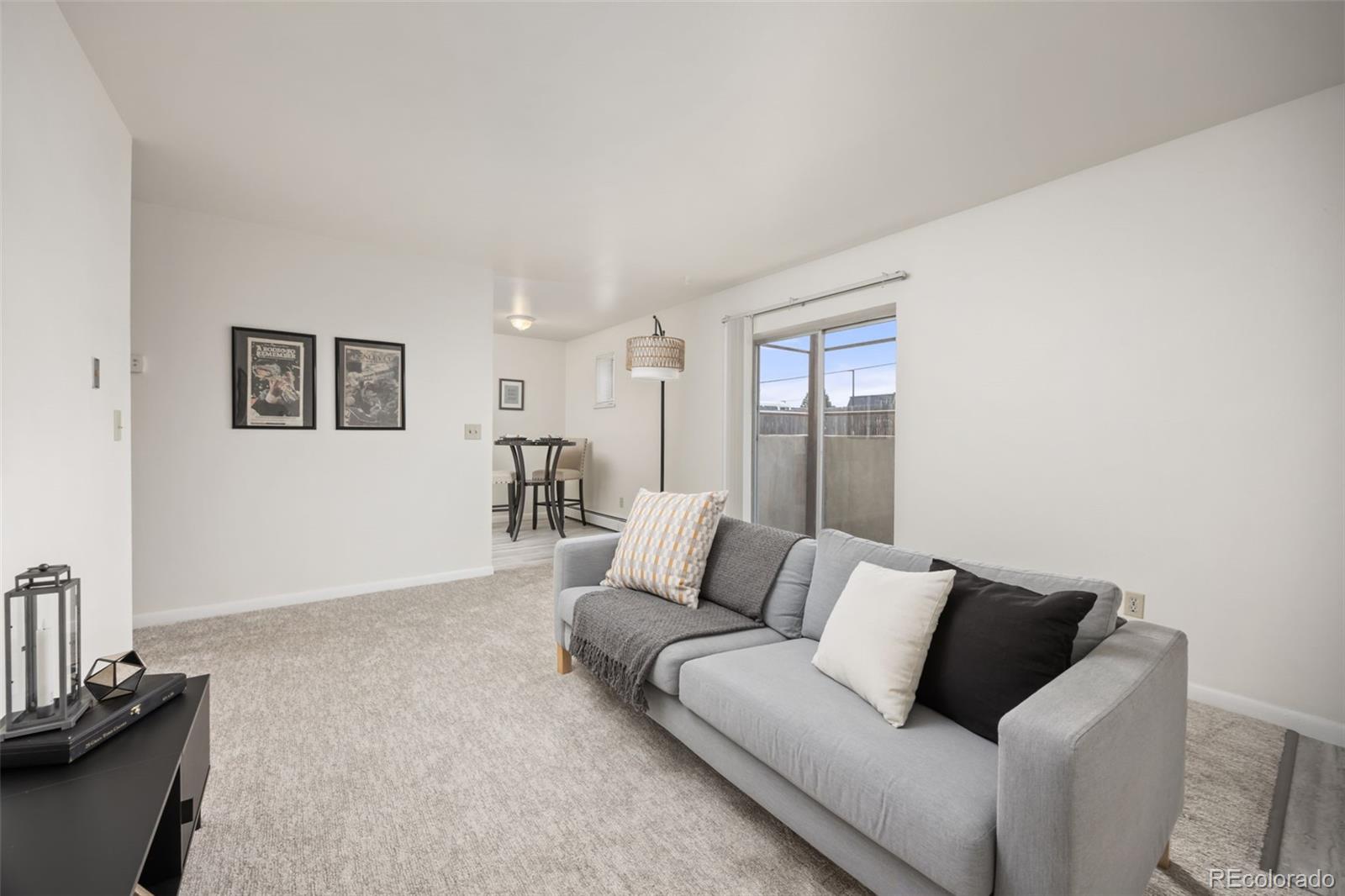 9380 West 49th Avenue, Unit 101 Wheat Ridge, CO 80033 - Photo 1 of 15 a living room with furniture and painting on the wall