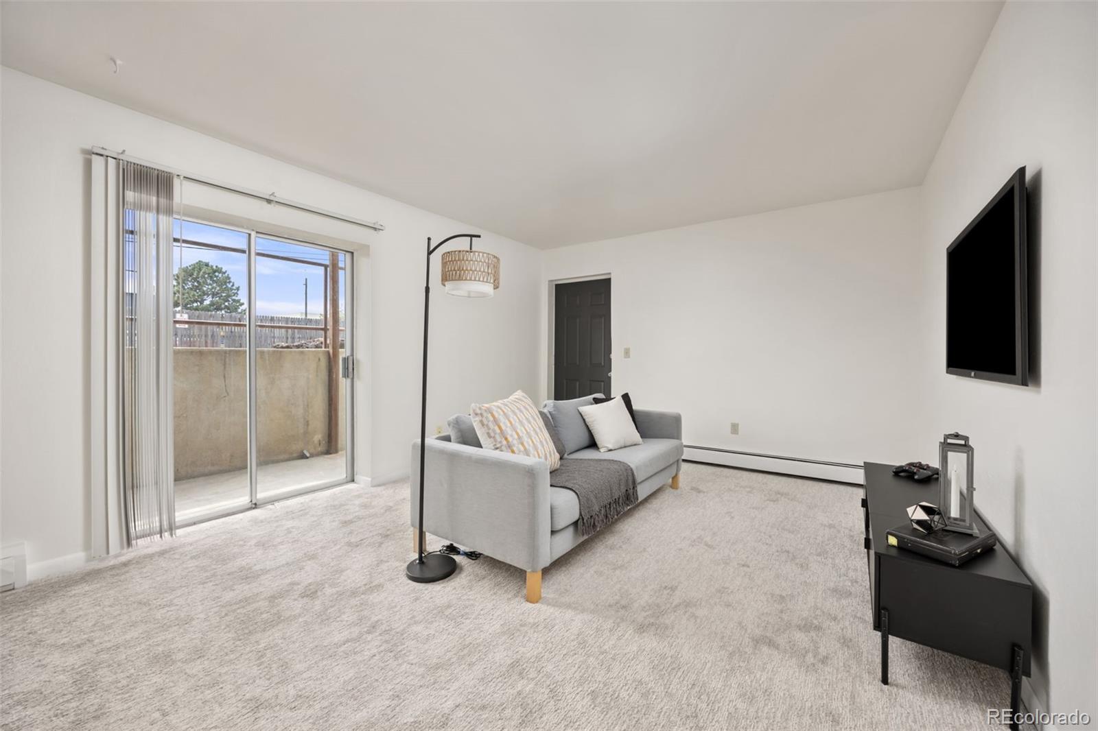 9380 West 49th Avenue, Unit 101 Wheat Ridge, CO 80033 - Photo 2 of 15 a living room with furniture and a flat screen tv
