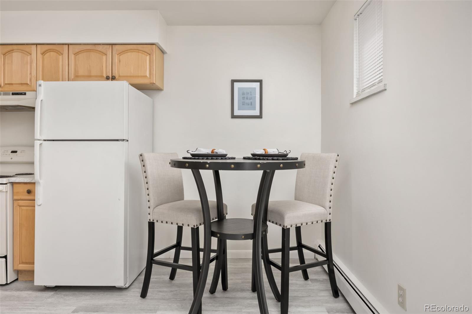 9380 West 49th Avenue, Unit 101 Wheat Ridge, CO 80033 - Photo 5 of 15 a kitchen with a table and chairs