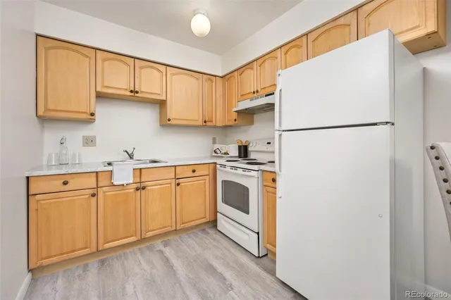 a kitchen with white cabinets and white appliances