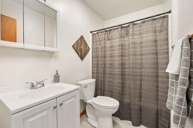 a bathroom with a sink a toilet and shower curtain