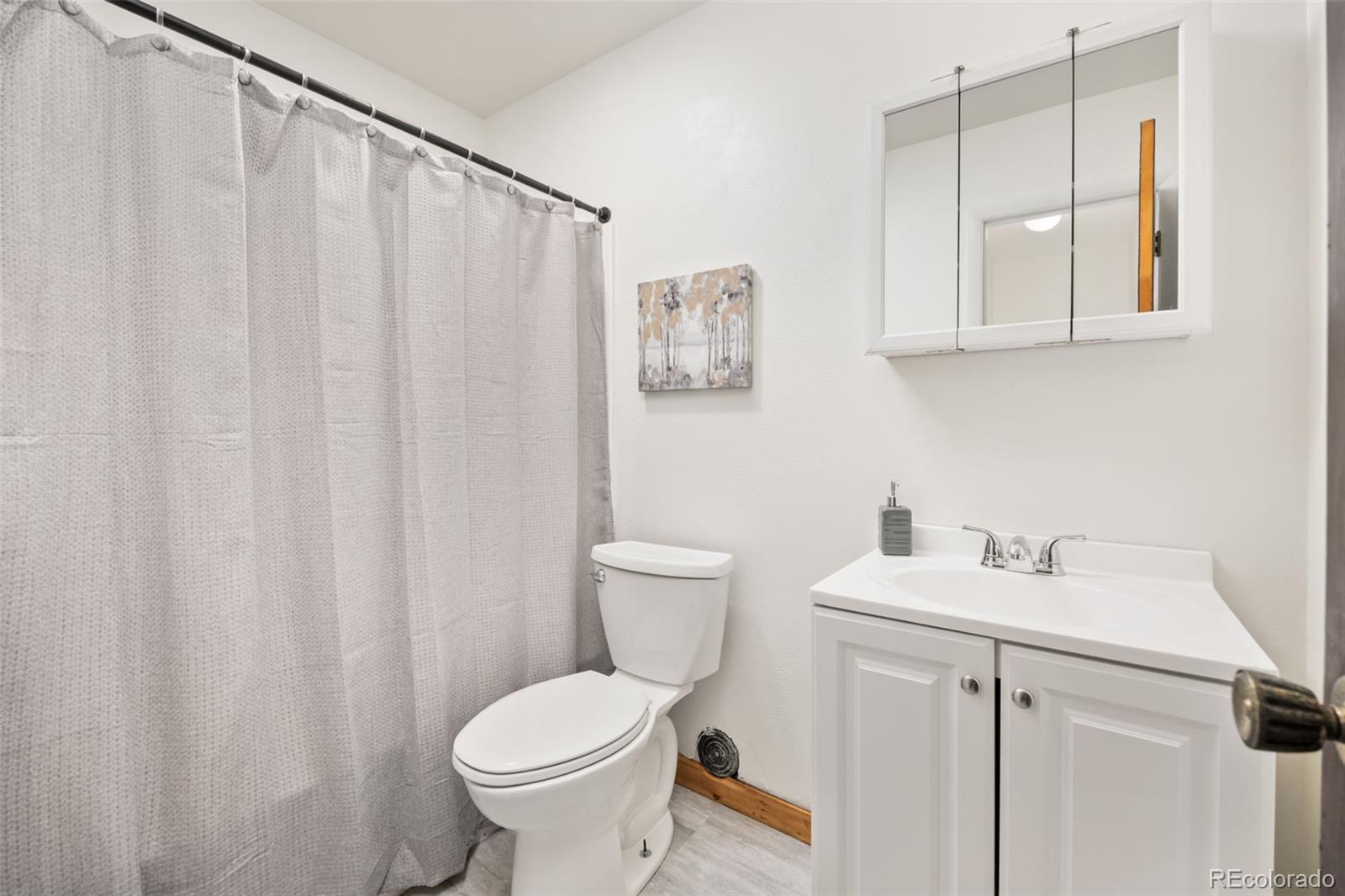 9380 West 49th Avenue, Unit 101 Wheat Ridge, CO 80033 - Photo 8 of 15 a bathroom with a sink toilet and vanity