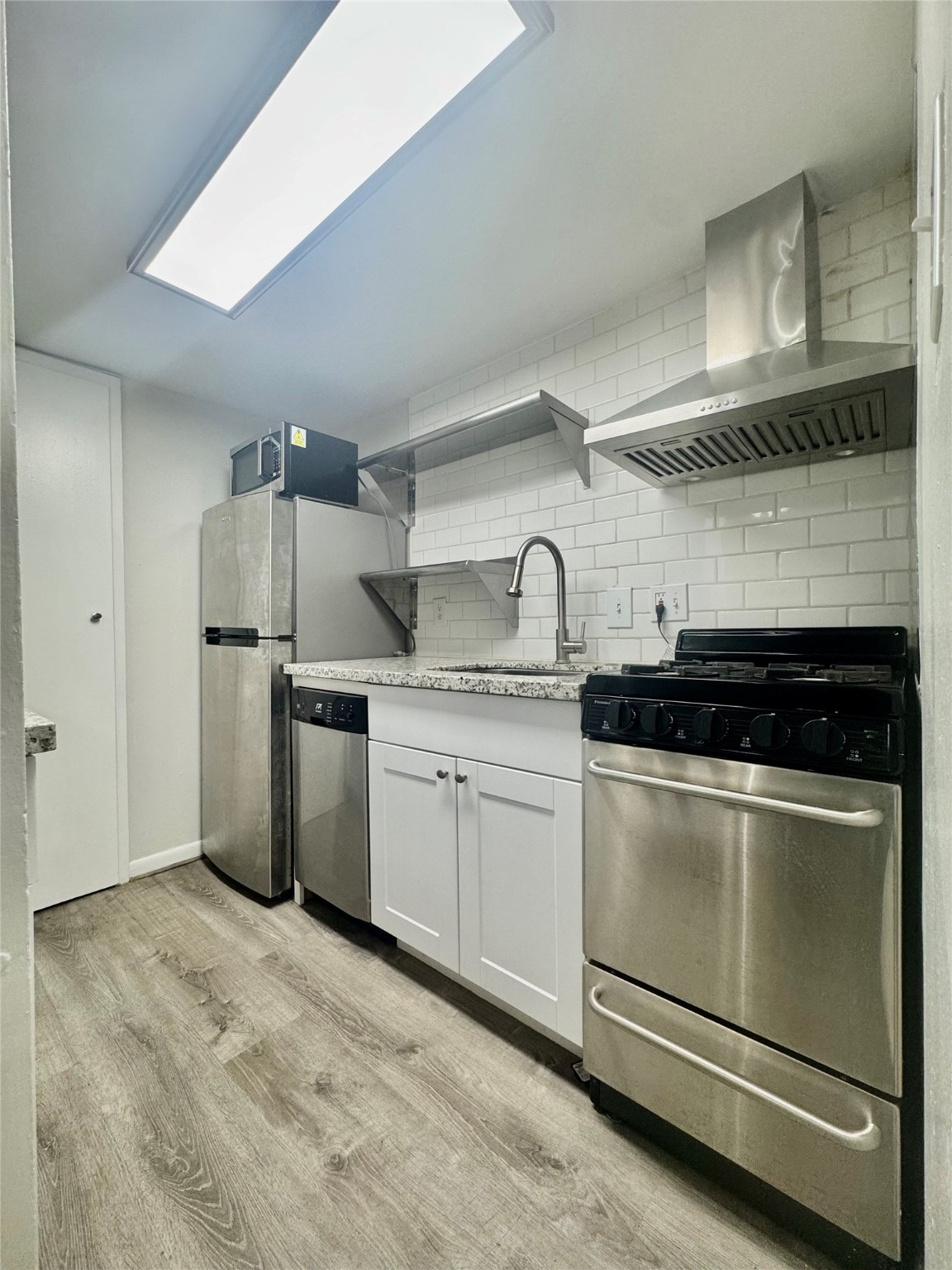 2006 Sul Ross Street, Unit 5 Houston, TX 77098 - Photo 6 of 13 a kitchen with a stove cabinets and refrigerator