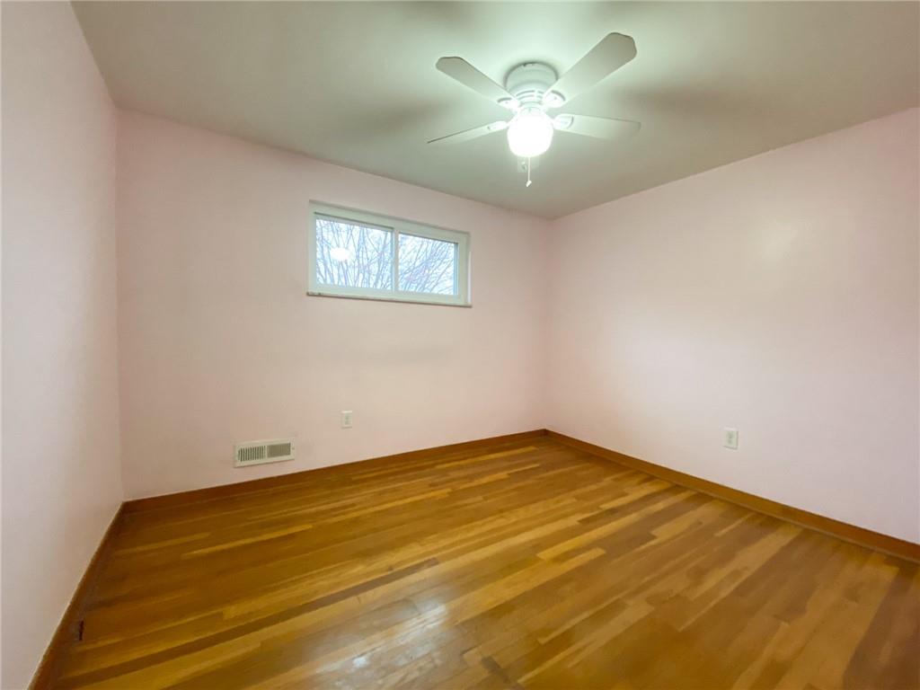 151 Thorne Road Washington, PA 15301 - Photo 17 of 25 an empty room with a chandelier fan and a fireplace
