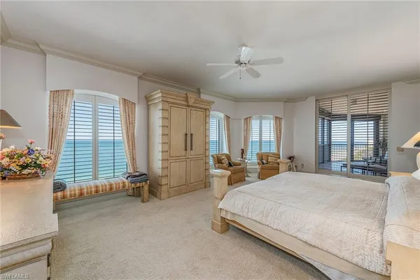 a spacious bedroom with a bed and a chandelier
