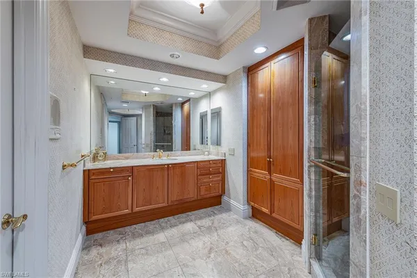 a large bathroom with a glass door shower and sink
