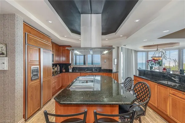 a kitchen with stainless steel appliances granite countertop table chairs and a refrigerator