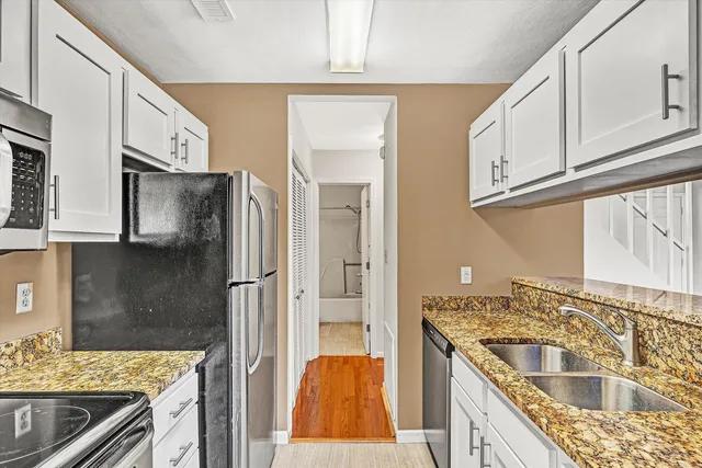 a kitchen with stainless steel appliances granite countertop a sink stove and refrigerator
