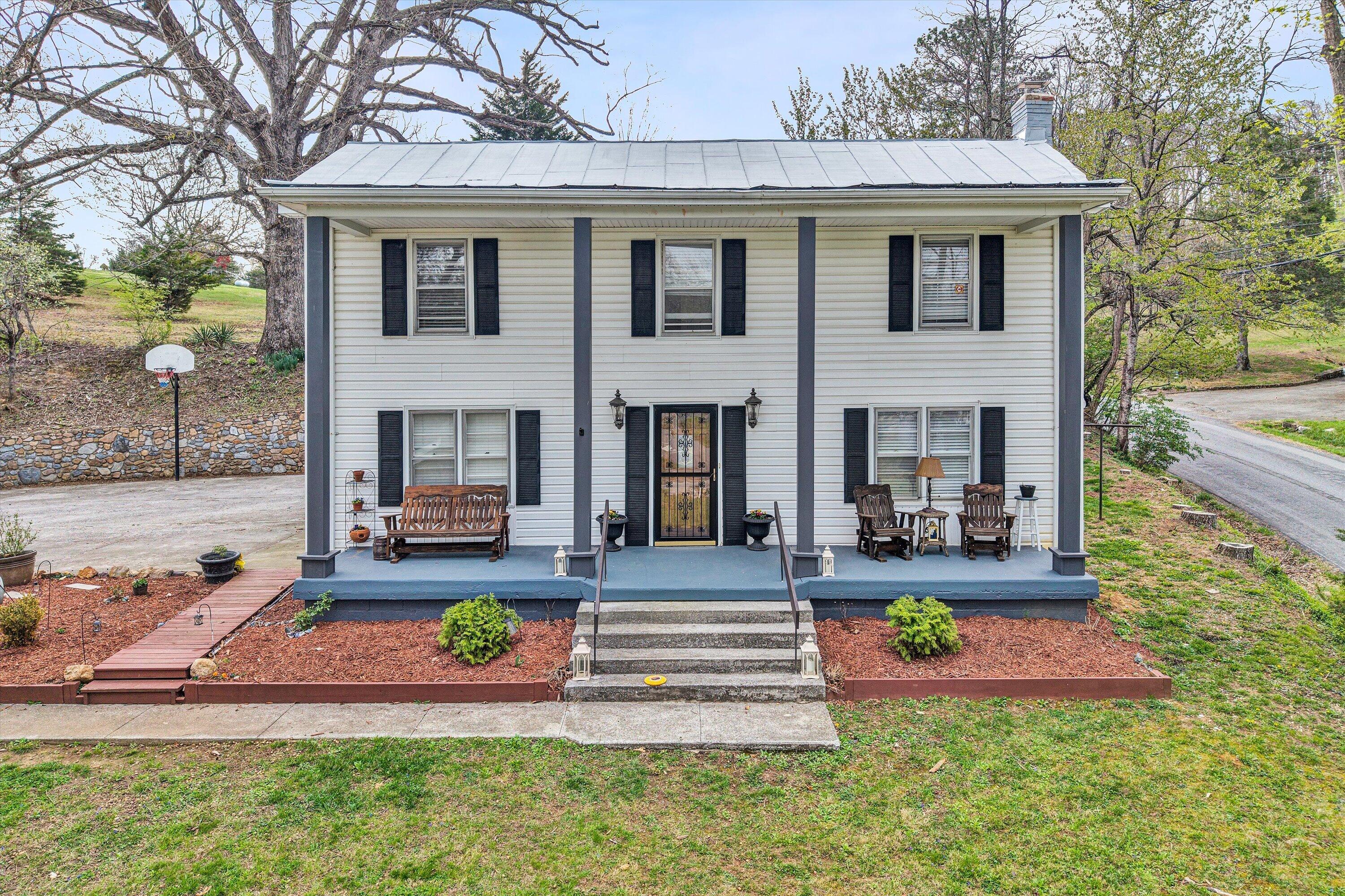 a front view of a house with yard and outdoor seating