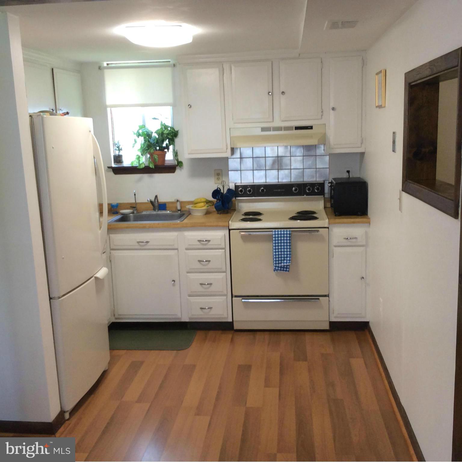 1539 Mayfield Road Edgewater, MD 21037 - Photo 4 of 17 a kitchen with stainless steel appliances a stove a refrigerator a sink a window wooden floor and cabinets