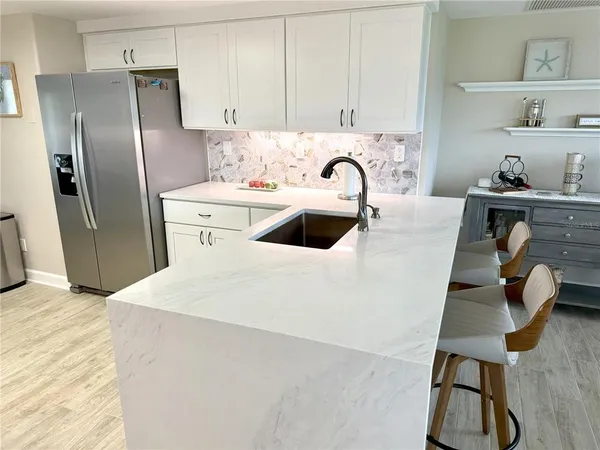 a kitchen with kitchen island a sink appliances and cabinets