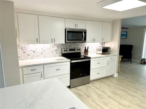 a kitchen with white cabinets and stainless steel appliances