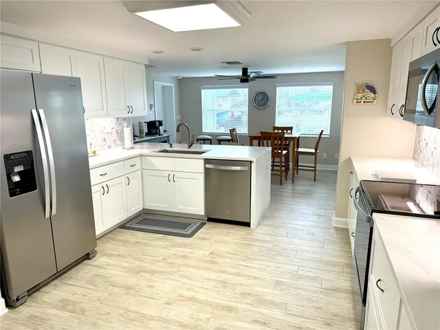 a kitchen with white cabinets and stainless steel appliances