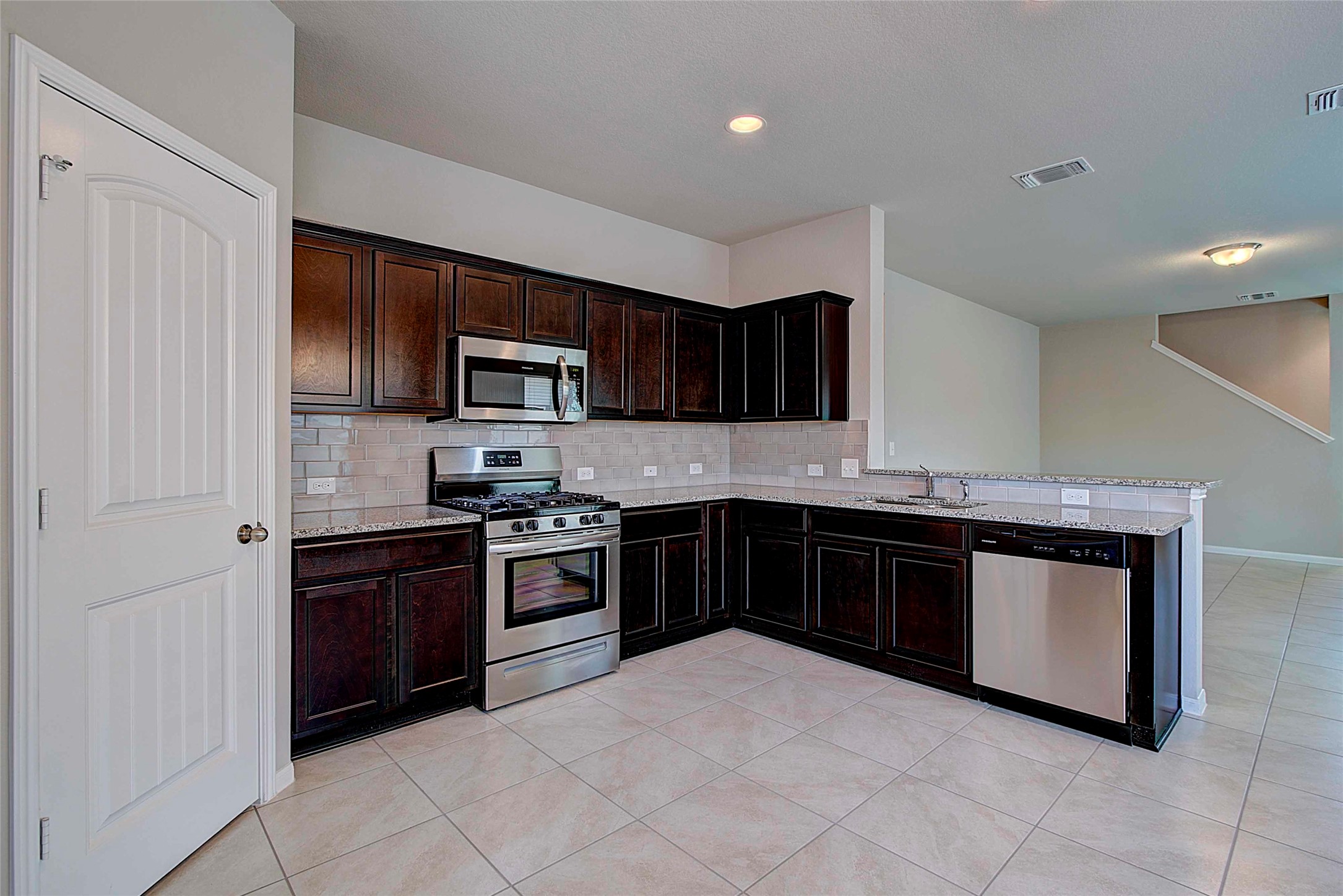 10404 Hatton Lane Austin, TX 78754 - Photo 7 of 27 a kitchen with stainless steel appliances granite countertop a stove top oven a sink dishwasher and a refrigerator