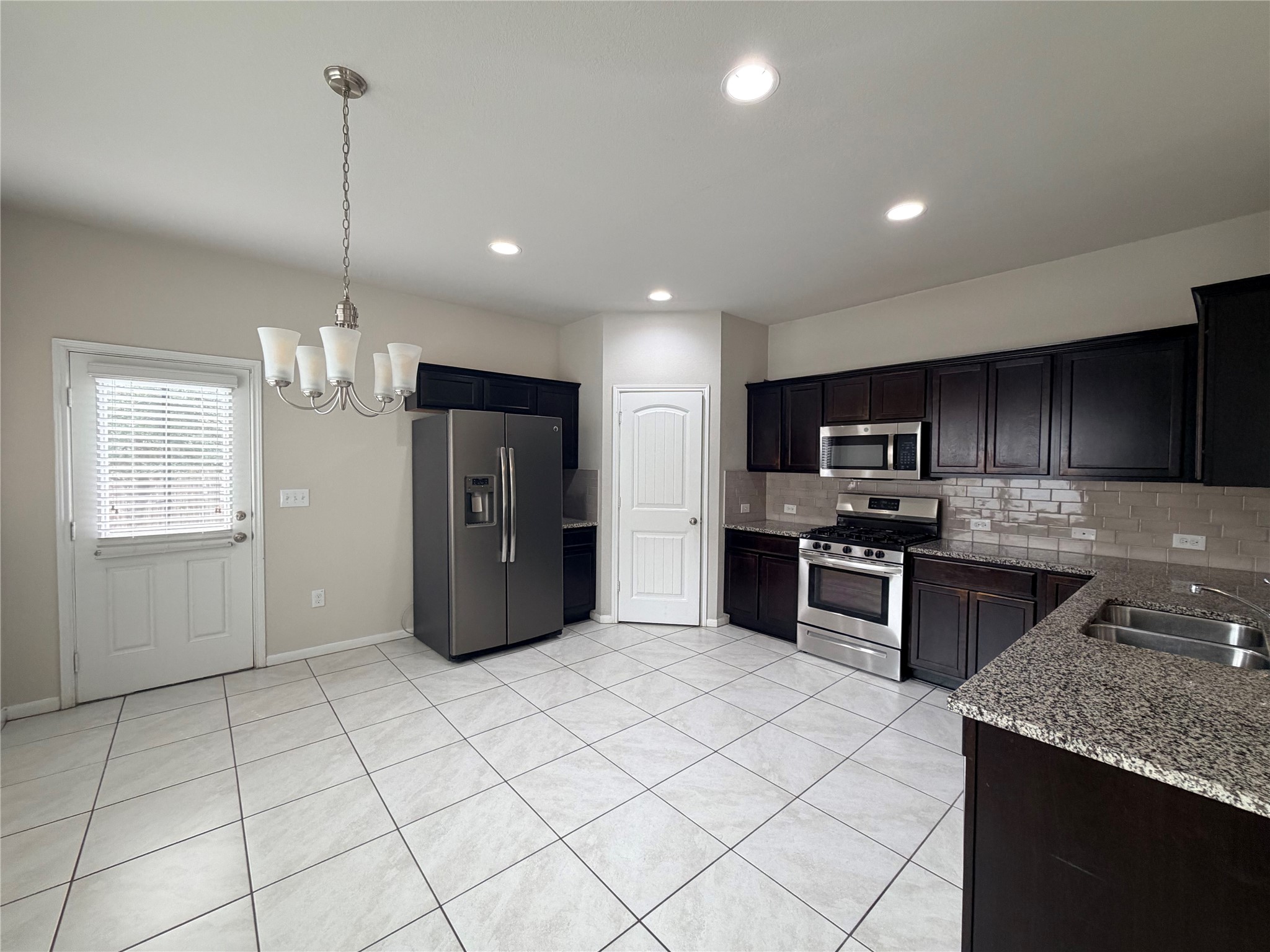 10404 Hatton Lane Austin, TX 78754 - Photo 9 of 27 a kitchen with stainless steel appliances granite countertop a refrigerator a sink dishwasher a stove and white cabinets with wooden floor
