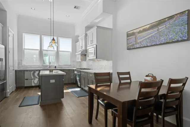 a kitchen with a table chairs a sink dishwasher window and dining table