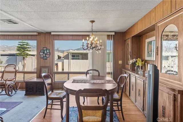 a dining room with furniture a chandelier and wooden floor