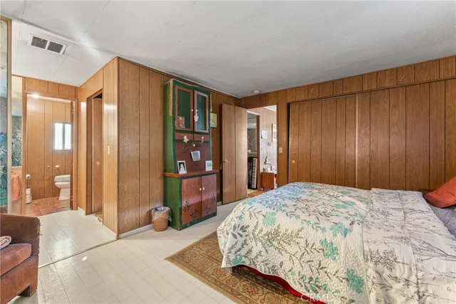 a bedroom with a large bed and large windows