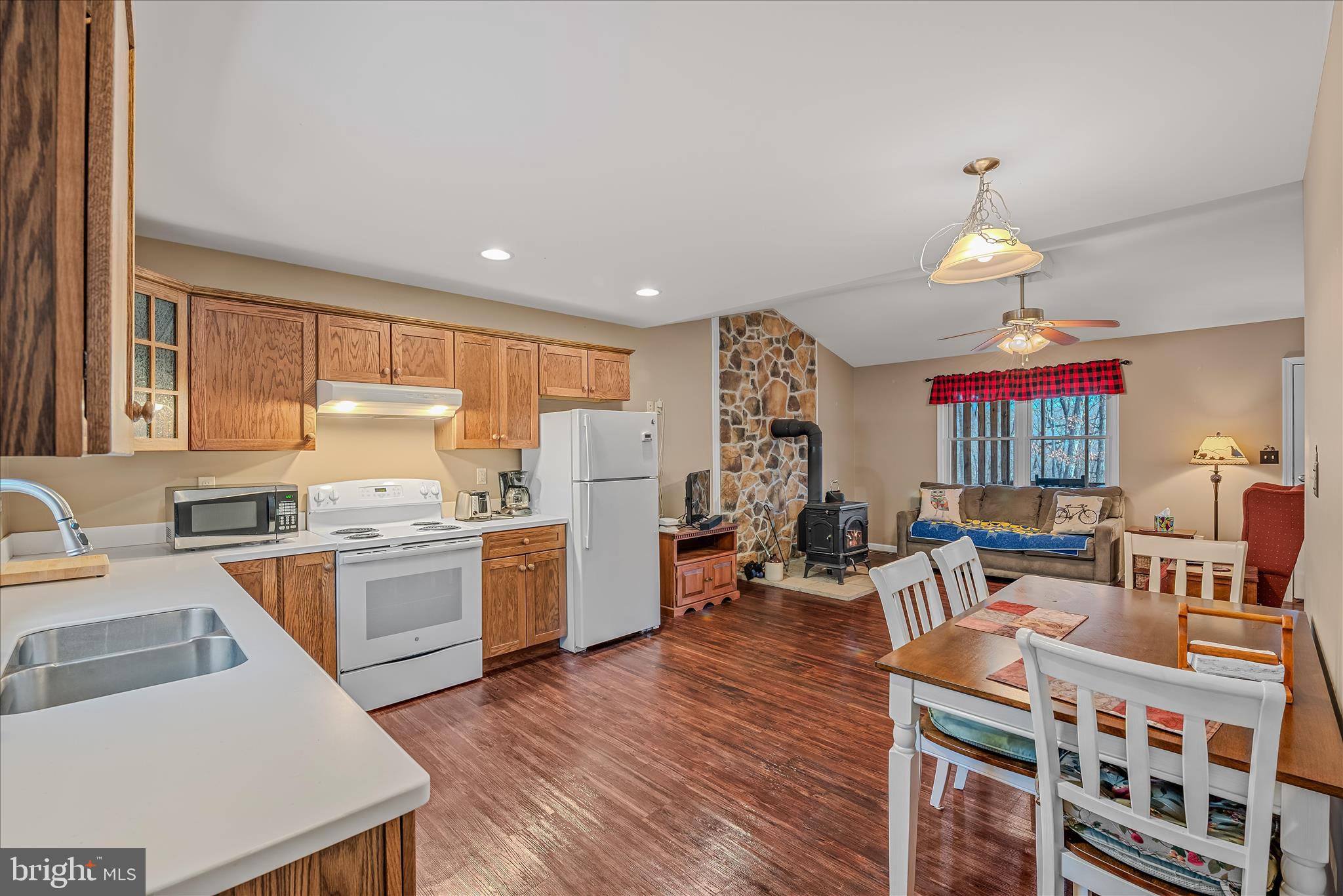 2910 Milo School Road Great Cacapon, WV 25422 - Photo 7 of 55 a open kitchen with stainless steel appliances granite countertop a stove refrigerator dining table and chairs with wooden floor
