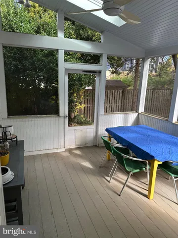 a view of a deck with table and chairs with wooden floor and garden view