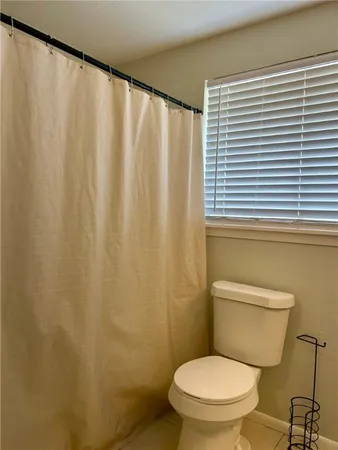 a white toilet sitting next to a shower curtain