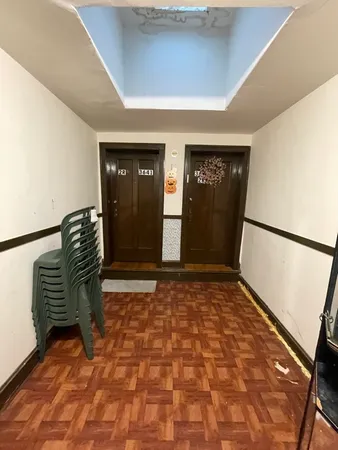 a view of a hallway with wooden floor and chair