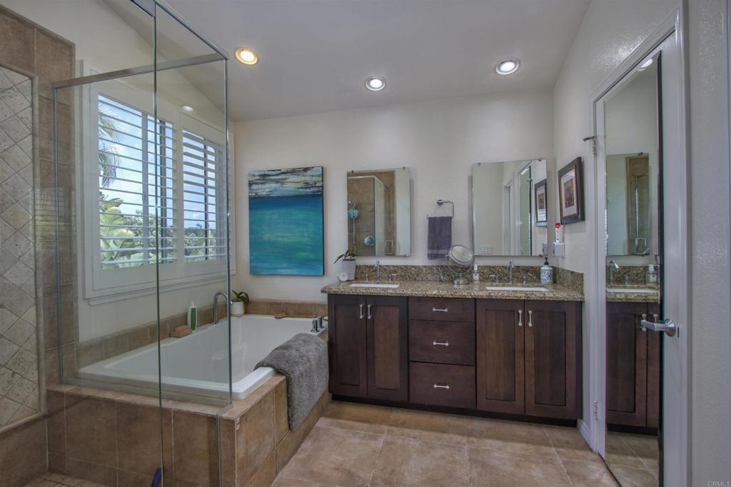 1684 Robin Place Carlsbad, CA 92011 - Photo 18 of 24 a bathroom with a granite countertop sink a mirror and a shower