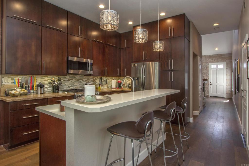 1684 Robin Place Carlsbad, CA 92011 - Photo 8 of 24 a kitchen with stainless steel appliances kitchen island granite countertop a sink and a refrigerator