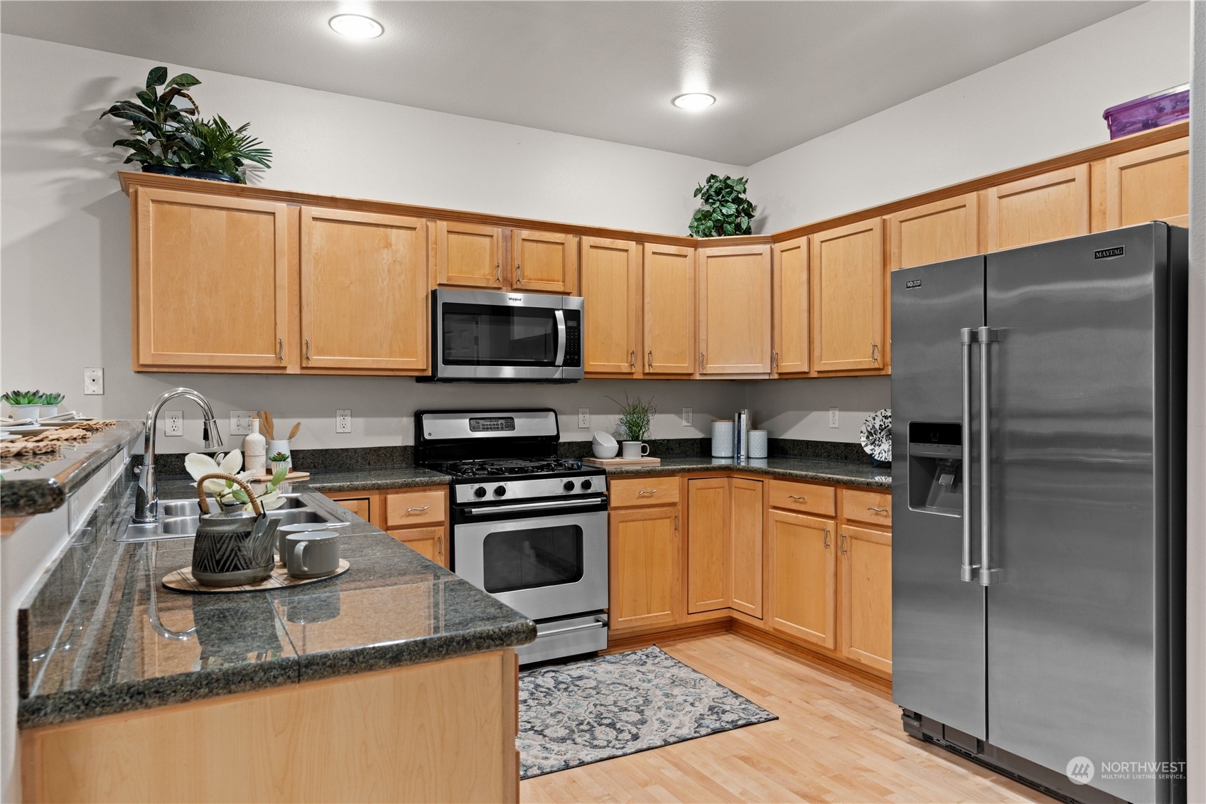 1012 186th Street Southeast Bothell, WA 98012 - Photo 8 of 40 a kitchen with stainless steel appliances granite countertop a refrigerator a stove top oven a sink and dishwasher