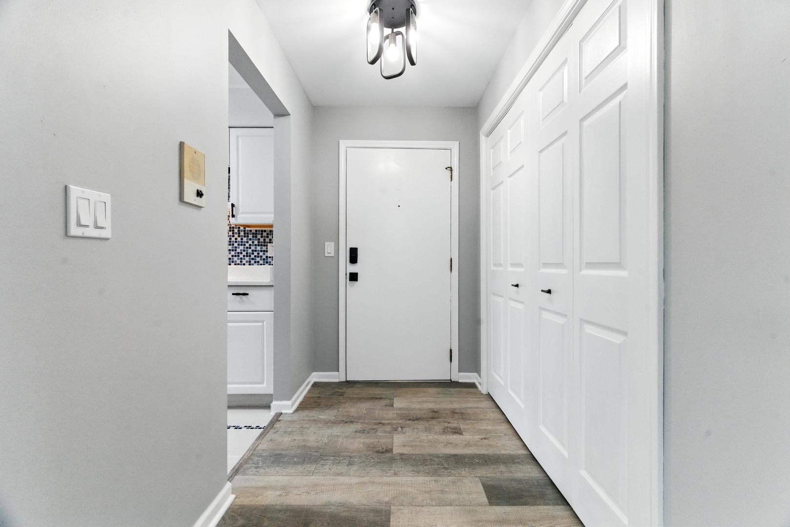 1415 Chartres Drive, Unit 1F Northbrook, IL 60062 - Photo 6 of 35 a view of a hallway with wooden floor and closet