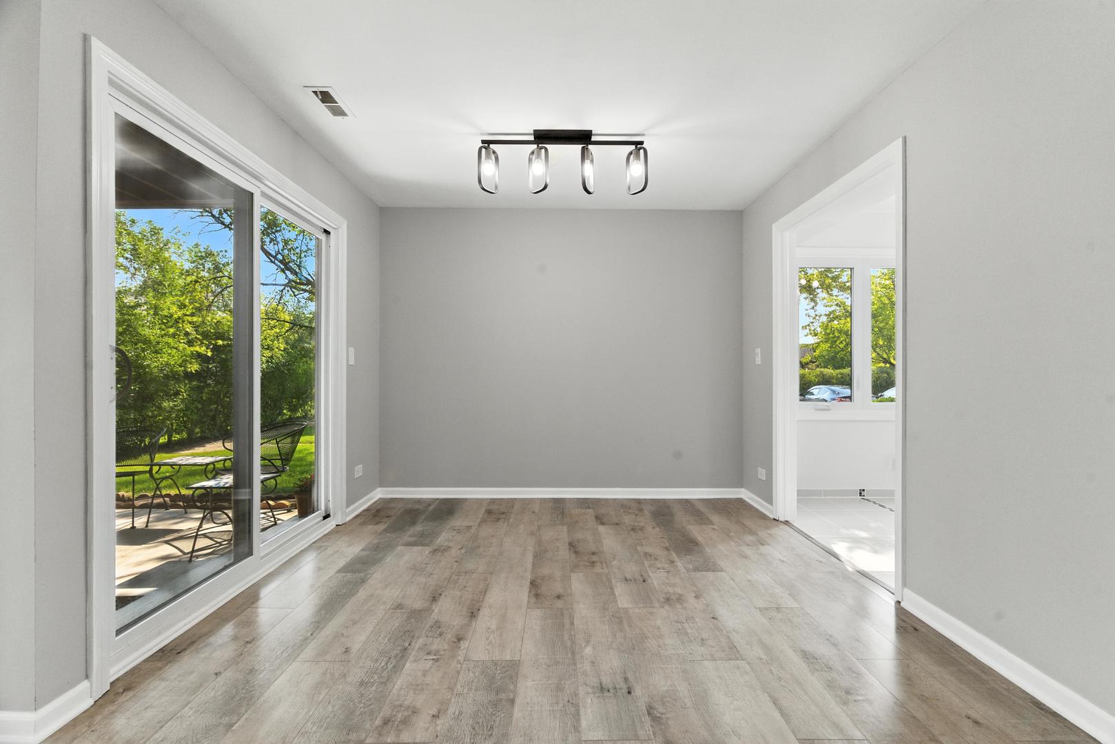 1415 Chartres Drive, Unit 1F Northbrook, IL 60062 - Photo 7 of 35 an empty room with wooden floor fan and windows