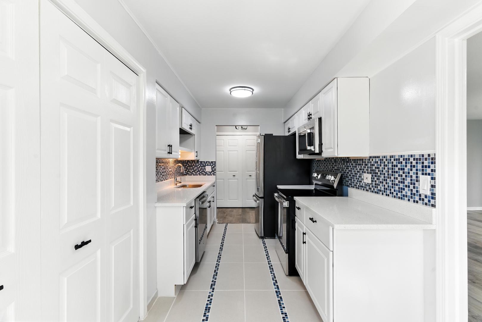 1415 Chartres Drive, Unit 1F Northbrook, IL 60062 - Photo 10 of 35 a kitchen with stainless steel appliances a refrigerator a sink dishwasher a stove and white cabinets with wooden floor
