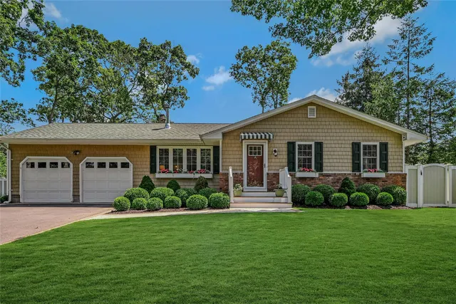 a front view of a house with a garden and plants