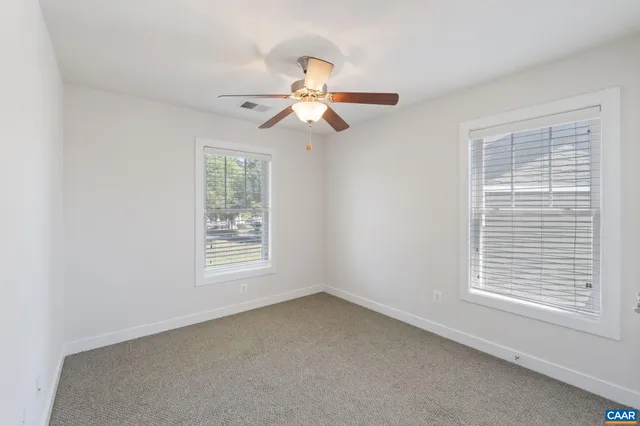 an empty room with a window and a fan