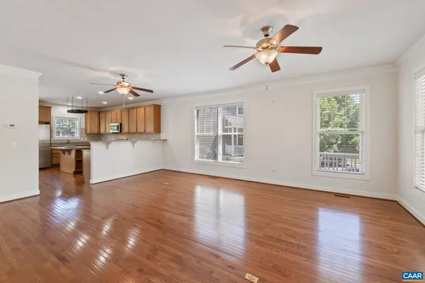 a view of a big room with wooden floor and a kitchen