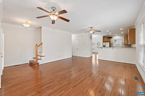 a view of a kitchen with wooden floor and a ceiling fan