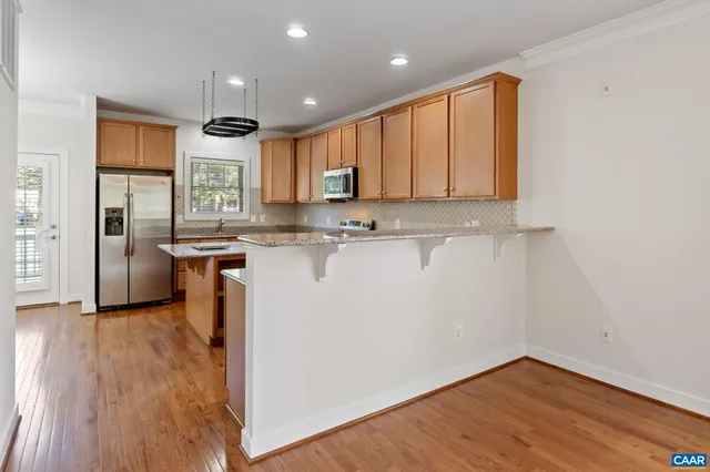 a kitchen with stainless steel appliances granite countertop a stove top oven a sink and a microwave