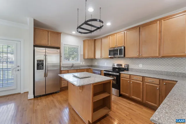 a kitchen with stainless steel appliances granite countertop a stove a refrigerator and a sink