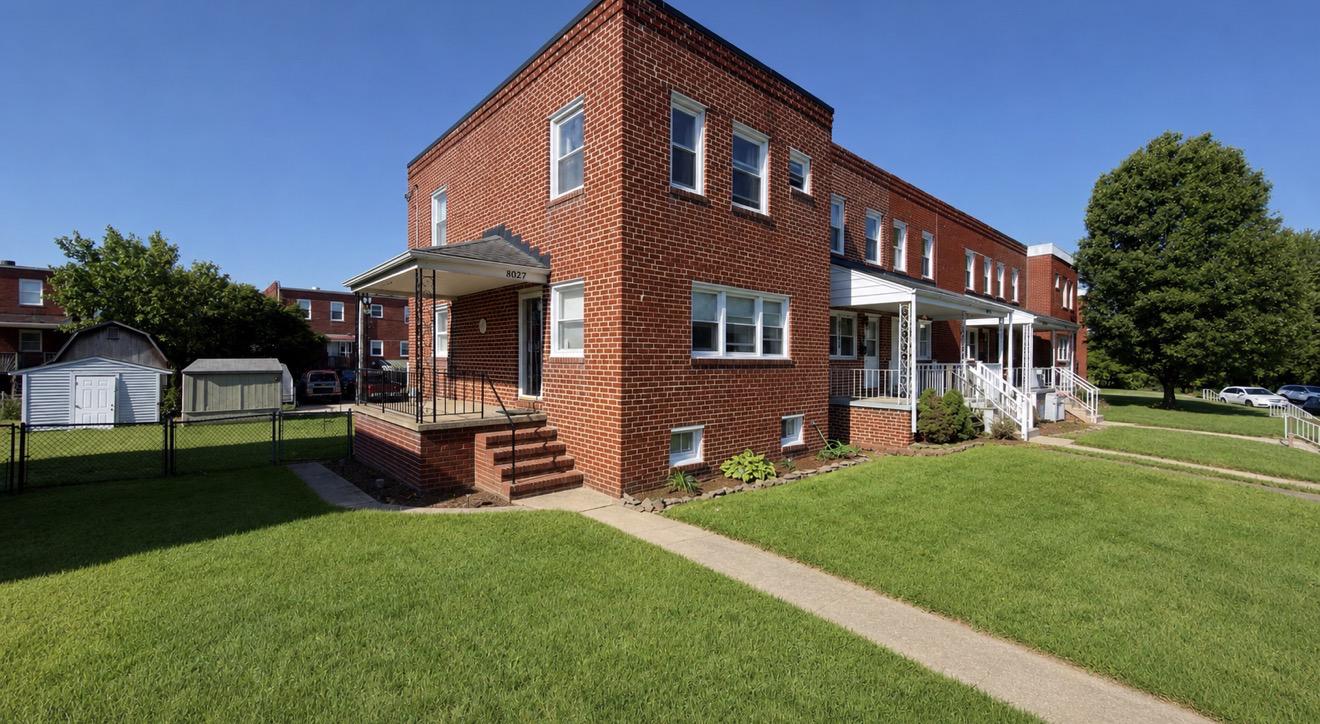 Charming brick home with lush lawn.