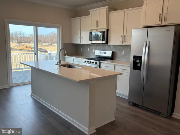 a kitchen with stainless steel appliances a refrigerator a stove a sink and a hard wood floors