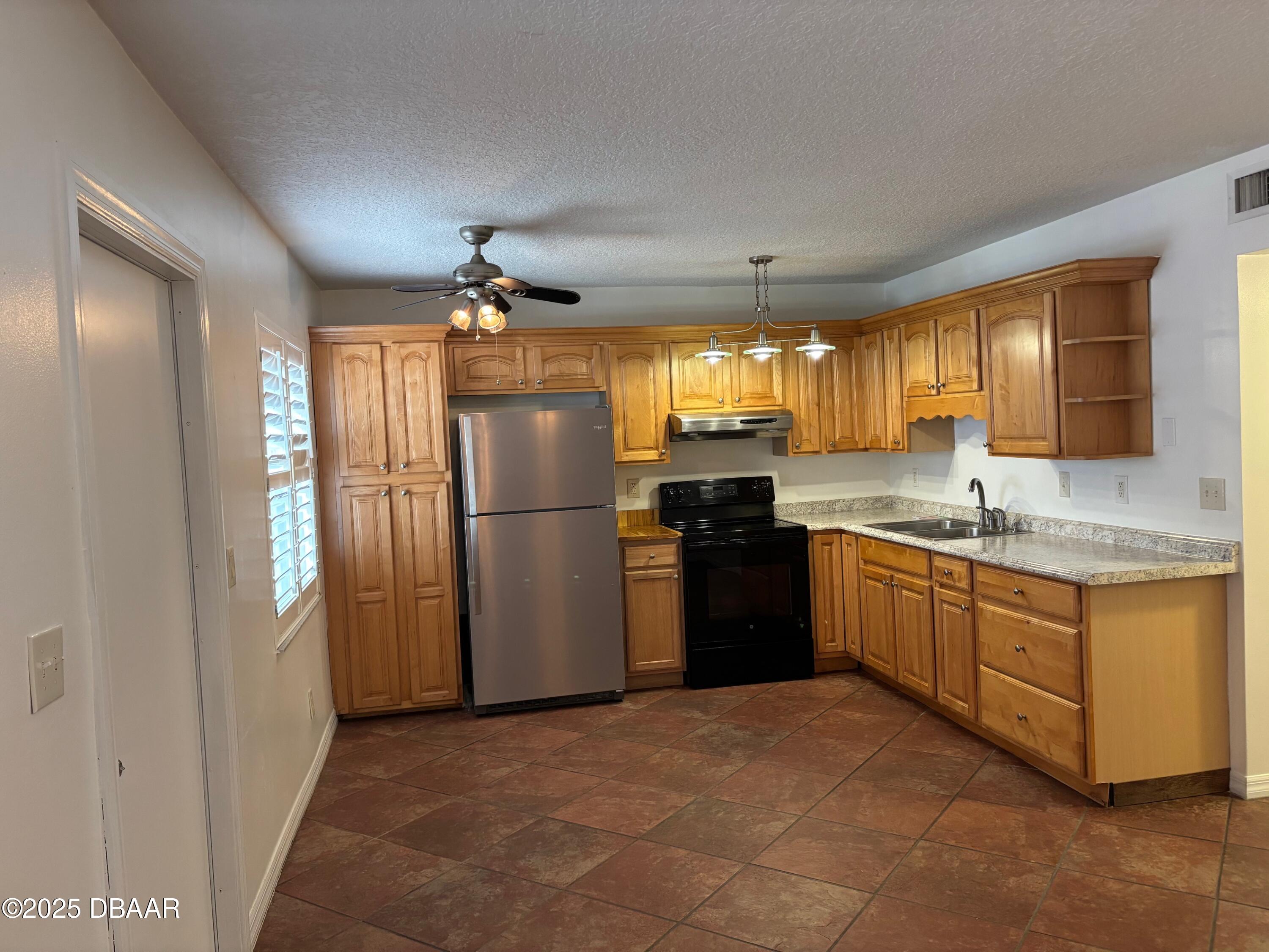3724 South Atlantic Avenue, Unit 4 Daytona Beach, FL 32118 - Photo 2 of 10 a kitchen with granite countertop a refrigerator stove top oven and sink