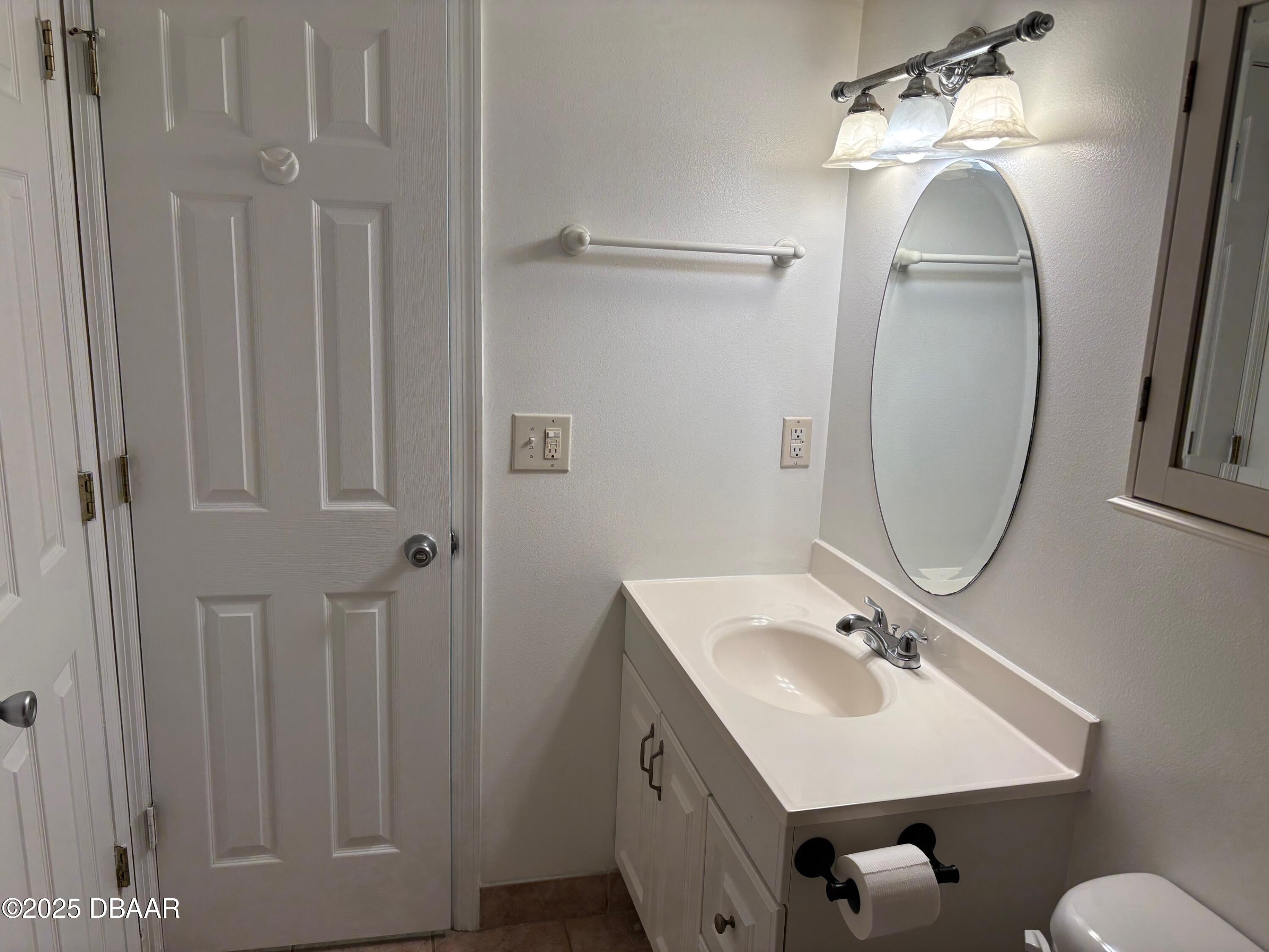 3724 South Atlantic Avenue, Unit 4 Daytona Beach, FL 32118 - Photo 5 of 10 a bathroom with a sink mirror and vanity